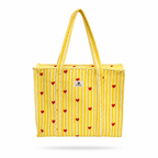 A yellow and white striped tote bag with small red hearts printed all over it, featuring thick braided rope handles and a small white brand label on the front.