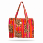 A woven tote bag featuring a vibrant pattern of tiger prints and vertical stripes in orange, pink, and red, with a small white brand tag in the center.