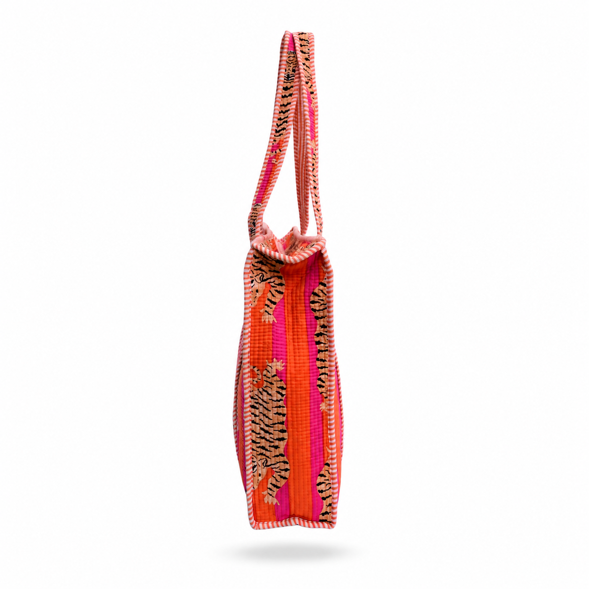 A vibrant woven tote bag with a bold tiger-stripe pattern in orange, pink, and black, shown from a side profile view against a white background.