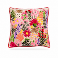 A square decorative throw pillow with a vibrant multicolor floral embroidery pattern on a light beige background, finished with a red pom-pom trim, shown against a plain white background.