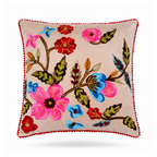A square decorative throw pillow with a beige background and colorful floral embroidery, finished with a red pom-pom trim, shown on a white background.