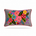 A rectangular gray throw pillow with a colorful embroidered floral pattern in the center and a red pom-pom trim around the edges, shown on a white background.