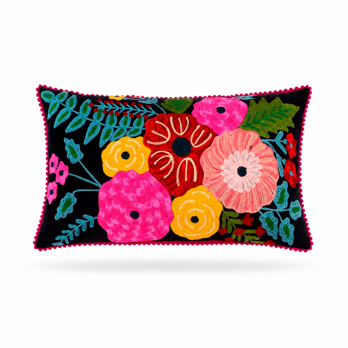 A rectangular decorative throw pillow with a vibrant floral embroidery pattern on a black background, finished with a pink pom-pom trim, shown against a plain white background.