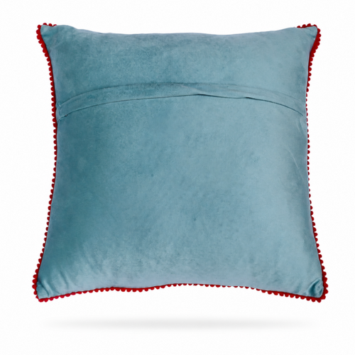 the backside of a square light blue throw pillow with a colorful embroidered floral pattern in the center and a red pom-pom trim around the edges, shown on a light blue background.