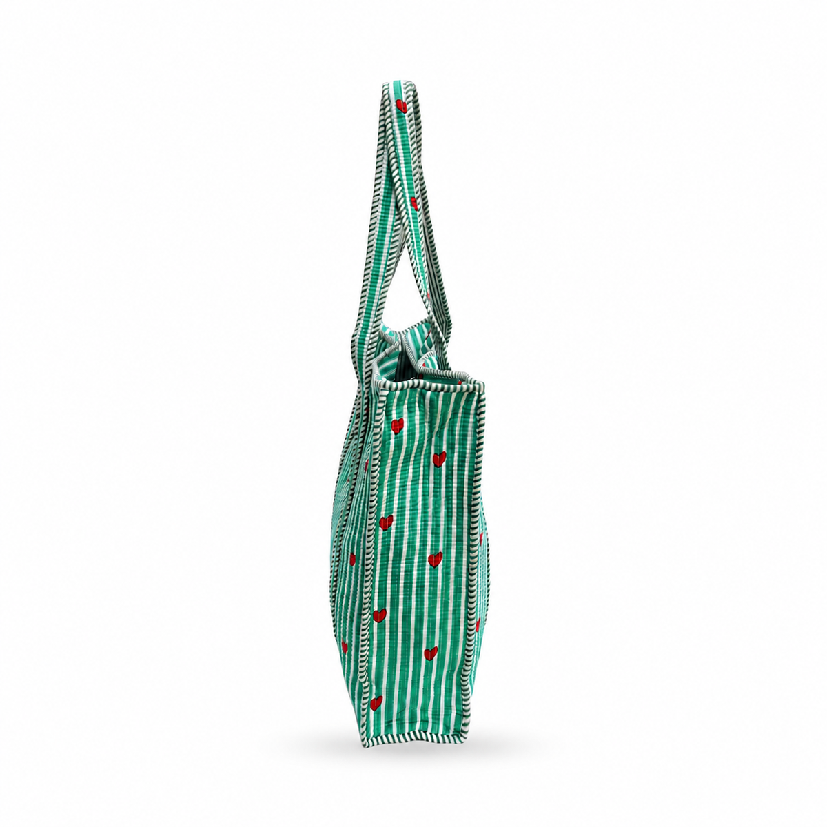 A green canvas tote bag with white vertical stripes, small red hearts, and white stitched edges, shown from a side profile view on a white background.