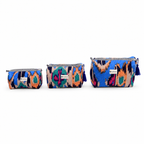 Three small zip pouches in a matching multicolor ikat pattern, arranged by size on a plain white background. Each pouch has a black and white striped zipper, a blue tassel zipper pull, and a small white brand label.