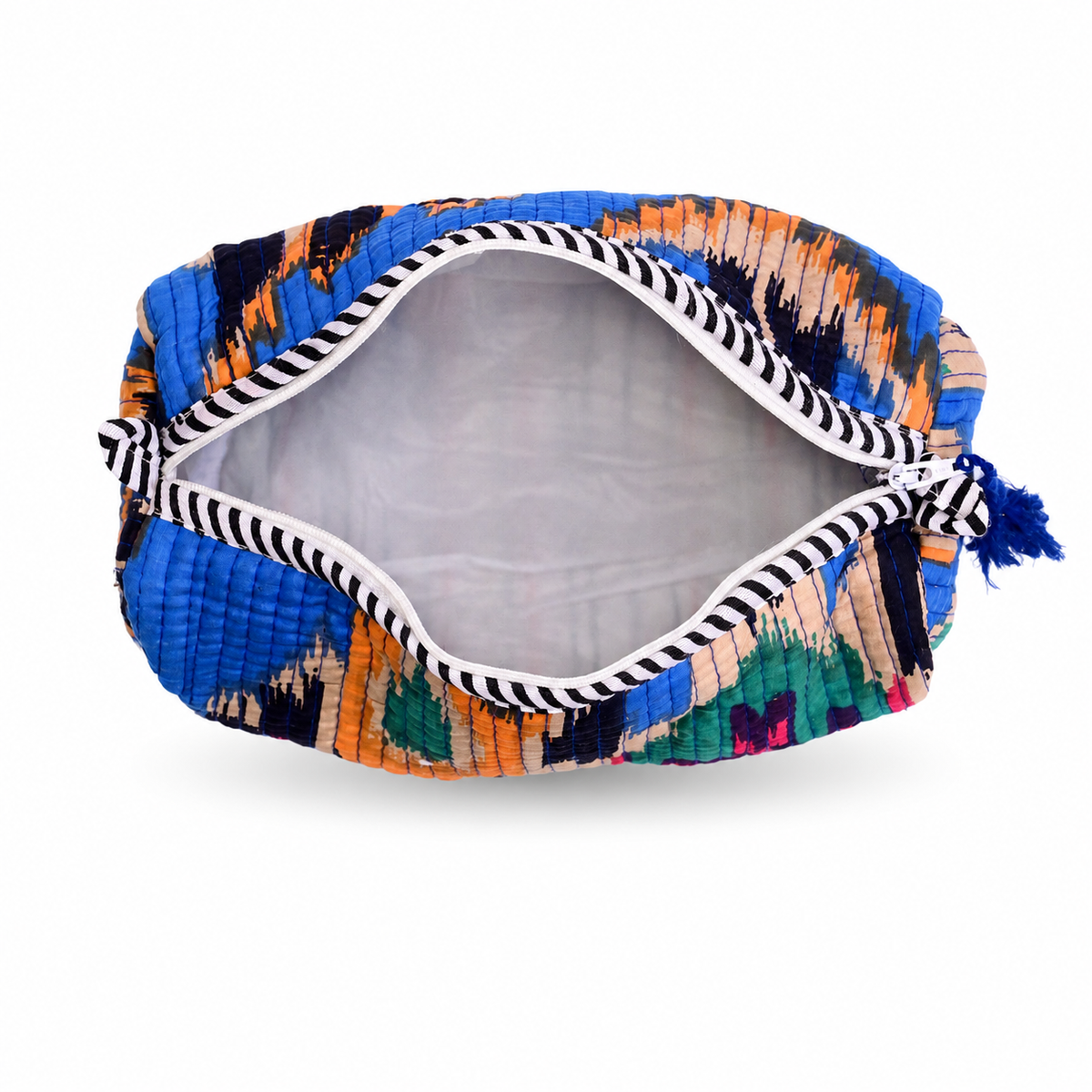 A zippered cosmetic pouch with a colorful ikat pattern in blue, orange, black, and green, featuring a black and white striped rope zipper and a blue tassel, shown on a white background.