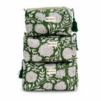 Three stacked quilted cosmetic pouches in green and white floral print with tassel zipper pulls, shown on a white background.