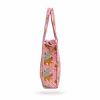 A pink woven tote bag with a pattern of leopards and trees, featuring a pink and white striped handle, shown against a pink white background.