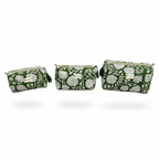 Three woven clutch bags in a matching  pattern flowers on a green background, displayed in ascending sizes.
