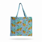 A woven tote bag with a turquoise and purple patterned background, decorated with golden-yellow leopards, featuring two top handles and a small white brand patch on the front.