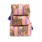 Three stacked woven cosmetic pouches by Veedhusartan, featuring a pink and purple striped pattern with tiger and zebra print panels, purple tassels, and a white brand label.