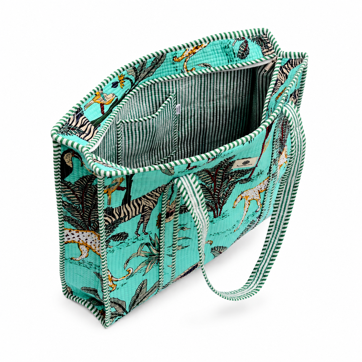 A side view structured tote bag with a vibrant turquoise and black jungle safari print, featuring illustrated zebras, leopards, palm trees, and flamingos, with matching woven shoulder straps, shown against a plain turquoise background with a pocket