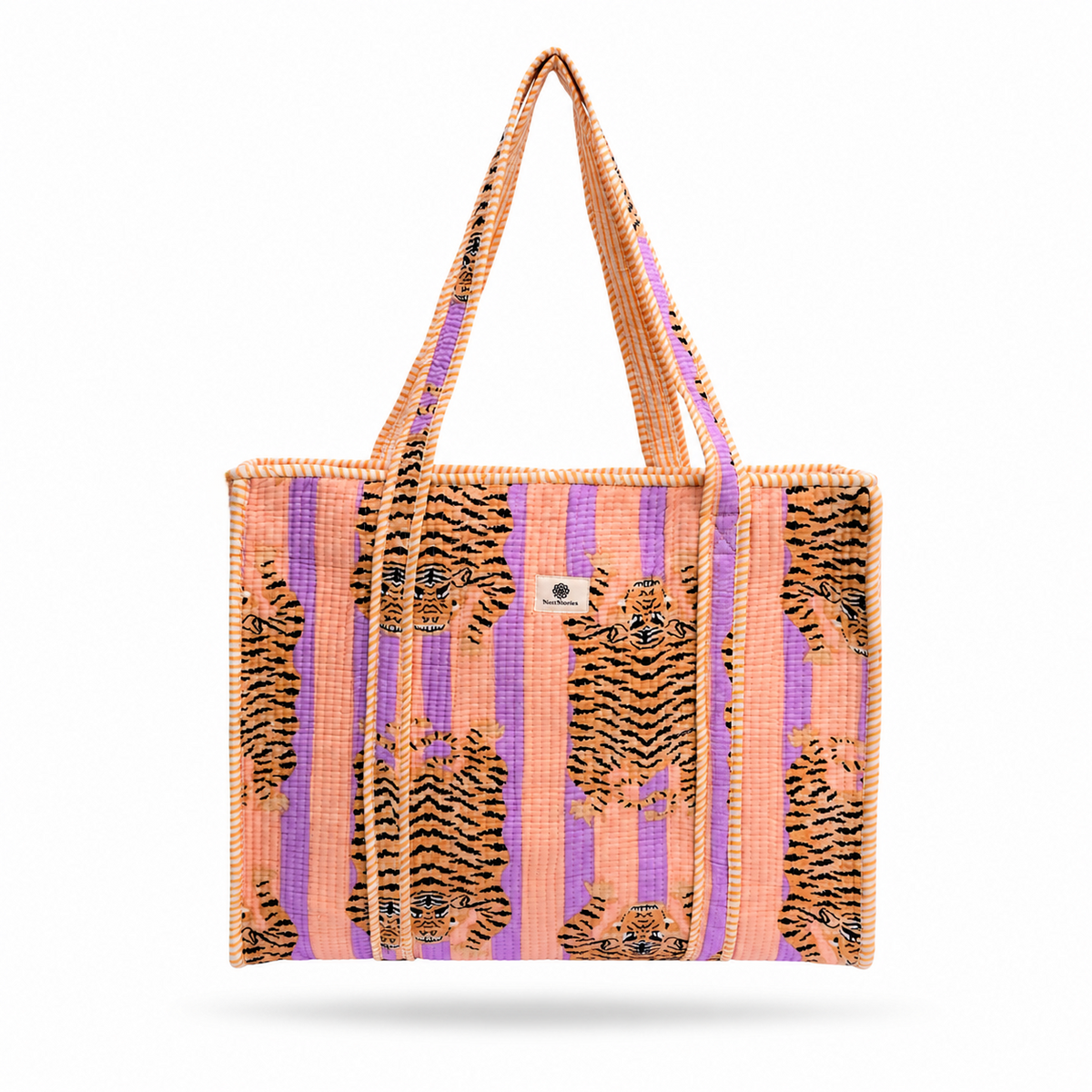 A woven tote bag featuring a pattern of black and orange tiger prints over vertical stripes of pink, purple, and orange, with a small silver metal logo on the front.