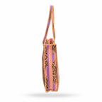 A woven shoulder bag shown from the side on a white background, featuring a pattern of black leopard spots over orange and purple woven stripes.