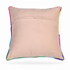 The backside of  a square decorative throw pillow with a colorful embroidered floral pattern on a cream background, finished with a multicolor pom-pom trim, shown on a off white background.