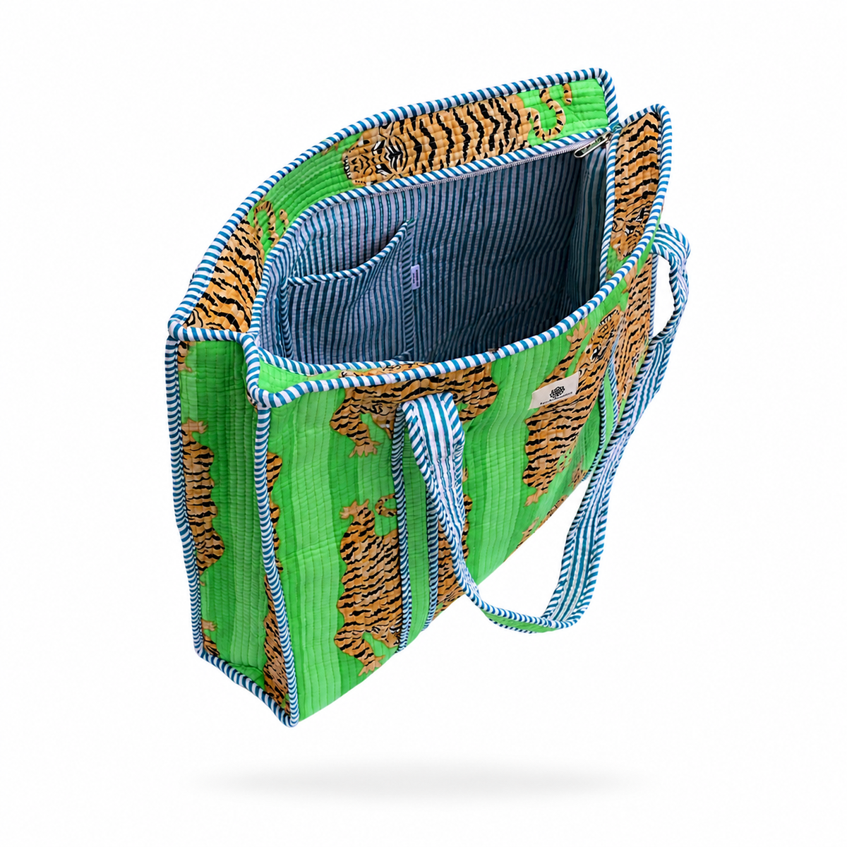 A tote bag with a green and orange tiger print exterior, blue and white striped handles and piping, and a blue striped fabric interior, shown floating against a white background.